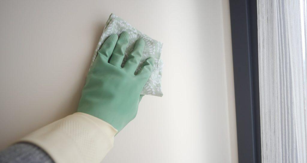 Cleaning a wall with a sponge in a bright room