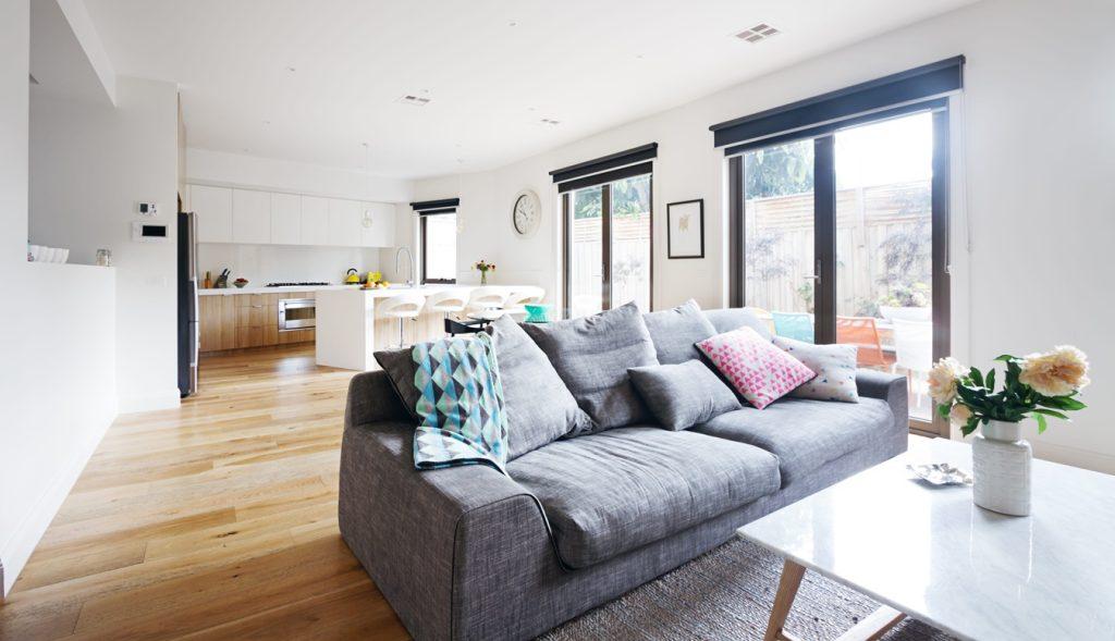 Open-plan living room and kitchen in a contemporary home with a grey sofa