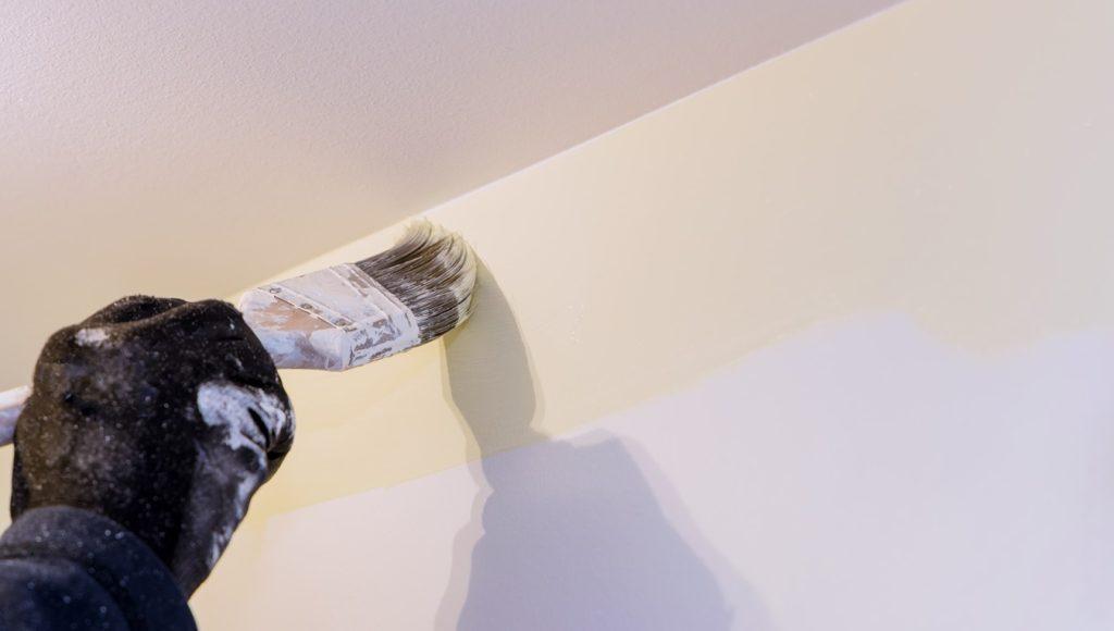 Painter painting the wall edge with a brush