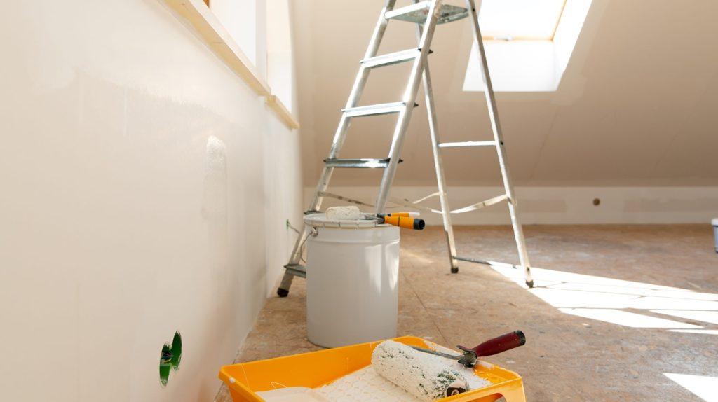 Painting tools — roller, paint bucket and paintbrush — in natural light