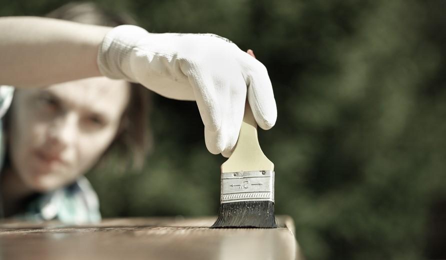 Carpenter treating wood with protection paint