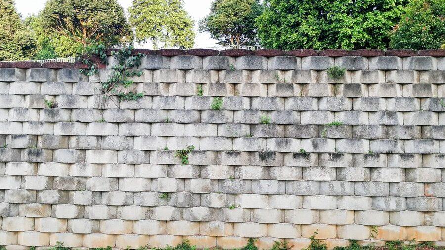 Interlocking designed retaining wall to manage earth erosion and landscaping