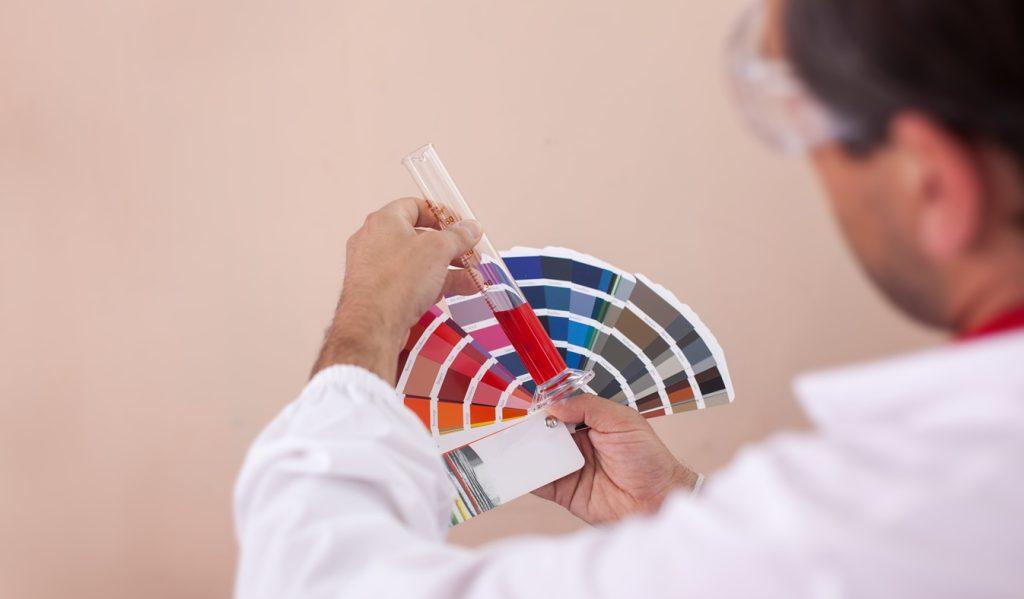 Man checks the colour of paint on a colour fan