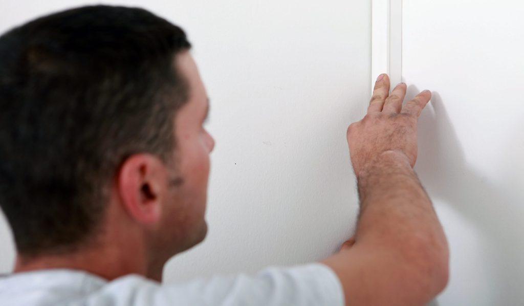 Man concealing wiring before painting