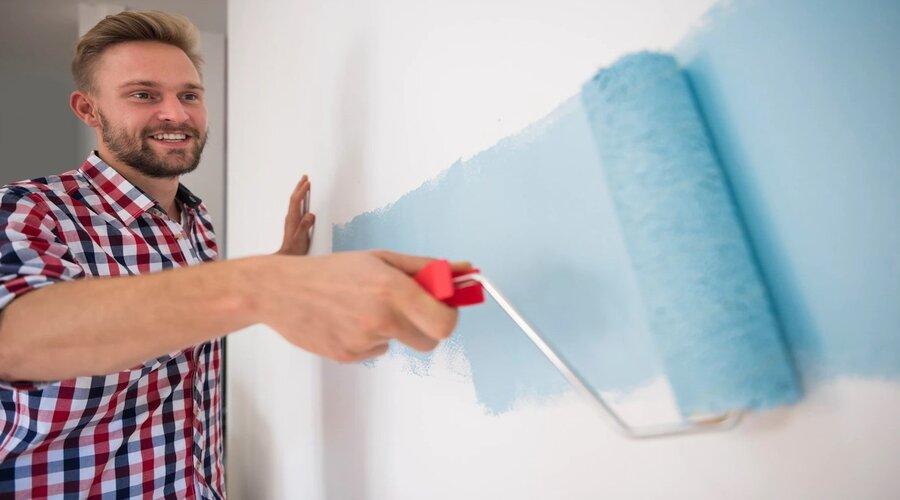 Man painting home wall