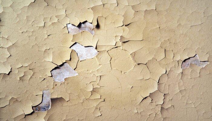 Texture of old cracked white paint on a concrete rough wall