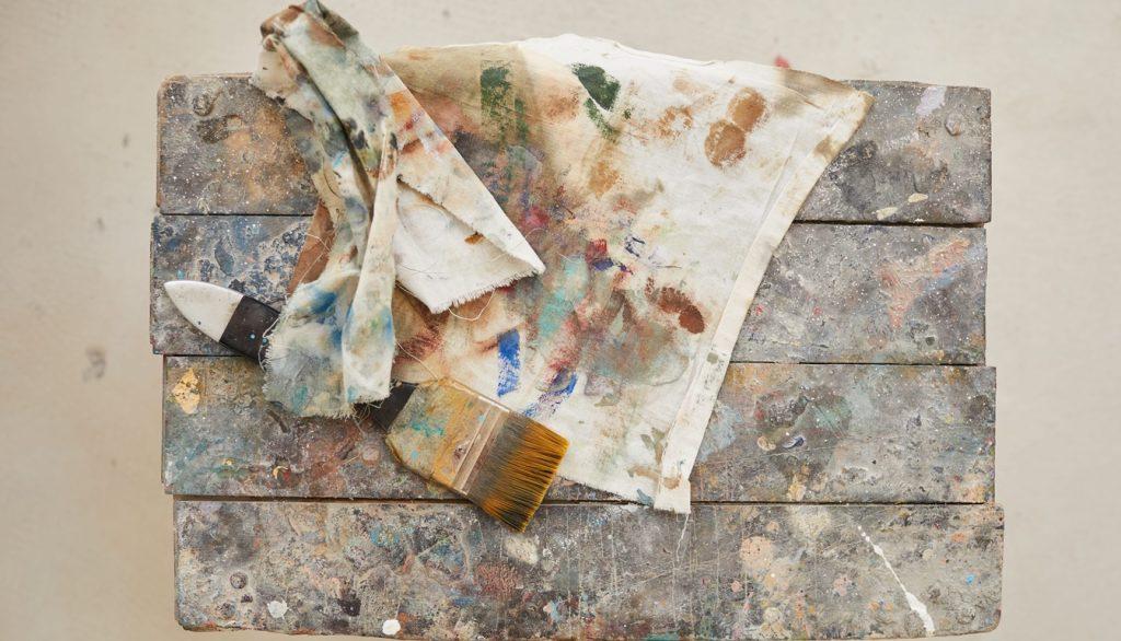 Top down view at cloth and paint brush over old wooden chair