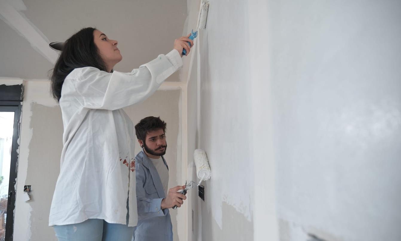 Young couple painting walls in their new house